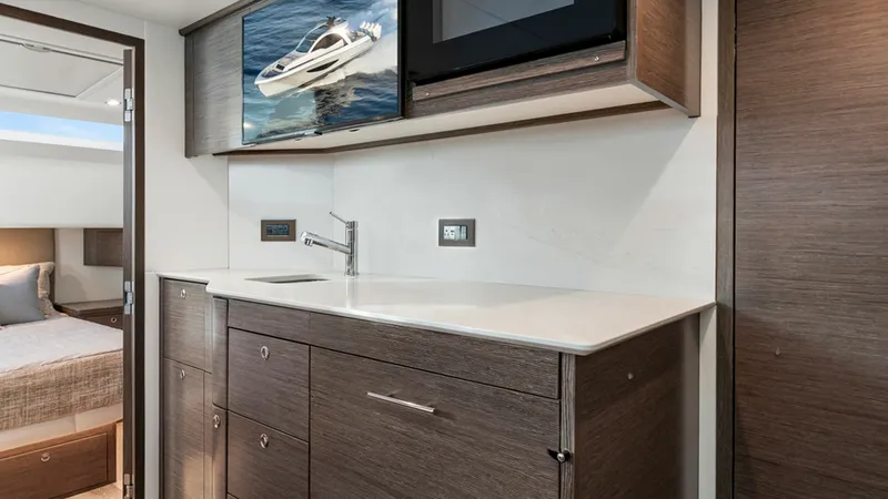 Slide: The Image of Modern Galley with Amenities - Valhalla 55 Sport Yacht This sleek galley on the 2027 Valhalla Boatworks 55 SY features modern cabinetry and a polished countertop, offering ample storage and workspace. A built-in microwave adds convenience, while the contemporary sink complements the minimalist design. The spa - 6332941