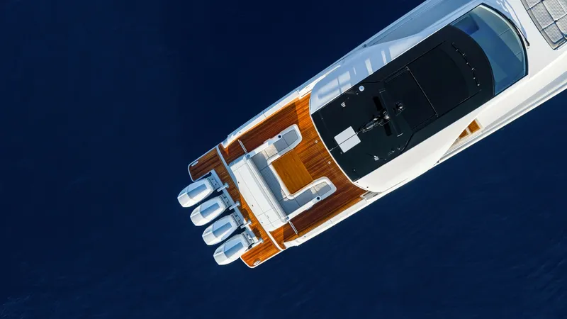 Slide: The Image of Aerial View of Aft Deck & Engines - Valhalla 55 Sport Yacht This aerial shot of the 2027 Valhalla Boatworks 55 SY showcases its expansive aft deck, elegantly finished with rich teak flooring. The vessel is powered by four high-performance outboard engines, promising exceptional speed and maneuverability. The layou - 6332943