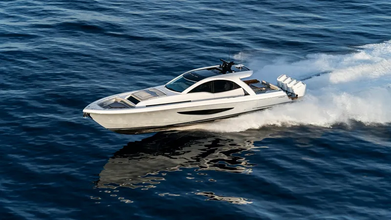 Slide: The Image of Dynamic Aerial View of 55 SY This stunning aerial shot showcases the sleek lines and powerful stance of the 2027 Valhalla Boatworks 55 SY. The boat cuts through the water effortlessly, highlighting its advanced hull design and robust outboard engines. The sunroof and expansive window - 6332950