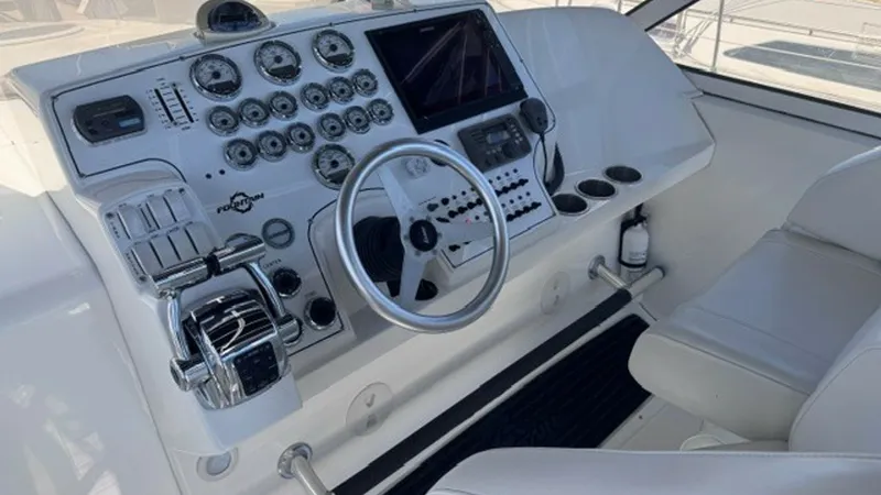 Slide: The Image of Helm Station with Navigation Equipment The helm station of the 2008 Fountain 38 Sportfishing Cruiser features a sleek and well-organized dashboard equipped with advanced navigation tools. The ergonomic layout includes a multi-functional steering wheel, intuitive throttle controls, and an array - 7788483