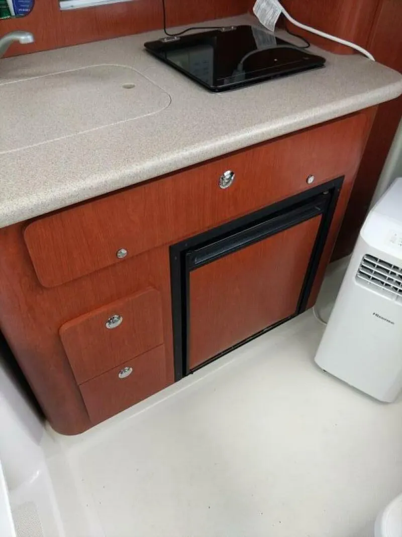Slide: The Image of Pro-Line 32 Express Starboard side view with galley countertop, cabinet and refrigerator. Sink and stove also visible. - 5533928