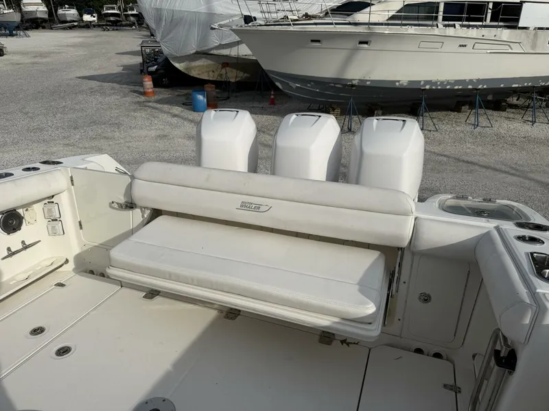 Slide: The Image of 2014 Boston Whaler 350 Outrage cockpit with rear bench seat open, looking from port side - 5681317