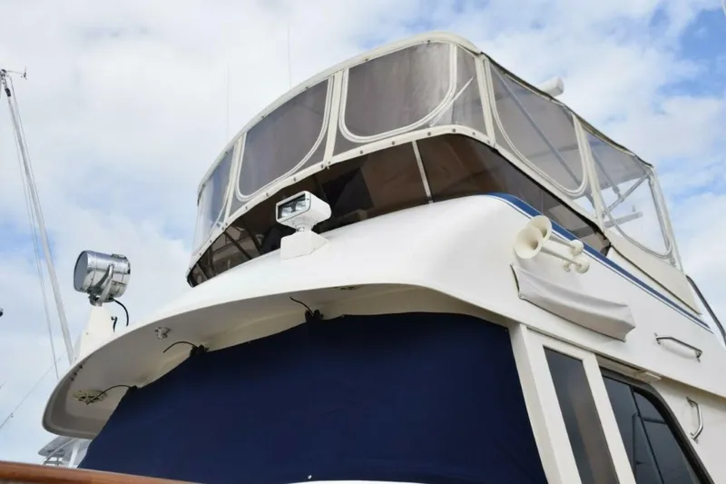 Slide: The Image of Navy Sunbrella canvas windshield mask, name board covers, and 3-sided flybridge enclosure with U-Zips - 5711468