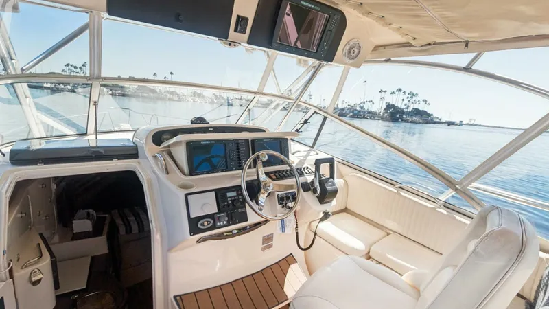 Slide: The Image of 2006 Grady-White 330 Express - "POLE POSITION": Helm Station with Seating The helm station of the 2006 Grady-White 330 Express, POLE POSITION, features a well-appointed captain's chair and comprehensive navigation controls. The area is enhanced by a wraparound windshield offering panoramic views and ample natural light. Adjacen - 6572963