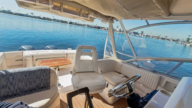 Slide: The Image of 2006 Grady-White 330 Express - "POLE POSITION": Helm and Cockpit Seating Area This image showcases the helm and cockpit seating area of the Grady-White 330 Express. The helm features a comfortable captain's chair and a well-equipped dashboard for seamless navigation. The cockpit offers additional seating with plush upholstery and a - 6572965