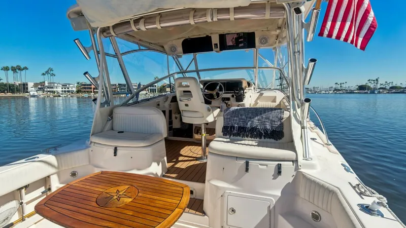 Slide: The Image of 2006 Grady-White 330 Express - "POLE POSITION":Spacious Cockpit with Helm View The cockpit of the Grady-White 330 Express boasts ample seating and a beautifully crafted teak table, perfect for entertaining guests. The helm features modern controls and a comfortable captain's chair, offering a commanding view of the water. This area - 6572955