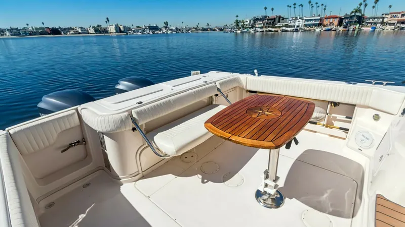 Slide: The Image of 2006 Grady-White 330 Express - "POLE POSITION": Spacious Aft Deck with Seating Area The aft deck of the 2006 Grady-White 330 Express offers a welcoming space with comfortable wrap-around seating, perfect for relaxation or entertaining guests. The beautifully crafted wooden table serves as a focal point, ideal for alfresco dining. Enjoy e - 6572956