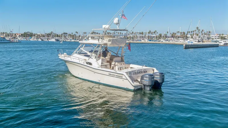 Slide: The Image of 2006 Grady-White 330 Express - "POLE POSITION": Aft View with Twin Outboards This 2006 Grady-White 330 Express 'POLE POSITION' is showcased with a clear view of its robust aft section and twin outboard engines. The spacious cockpit area is ideal for both relaxation and fishing, with ample seating and a well-designed layout. The ve - 6572968