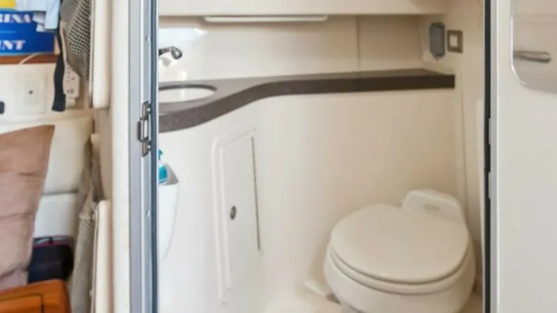 Slide: The Image of 2006 Grady-White 330 Express - "POLE POSITION": Compact Marine Head This image showcases the well-designed marine head on the Grady-White 330 Express. Featuring a compact layout, it includes a toilet, sink, and storage cabinet with sleek finishes. The efficient use of space ensures convenience and comfort during extended - 6572960