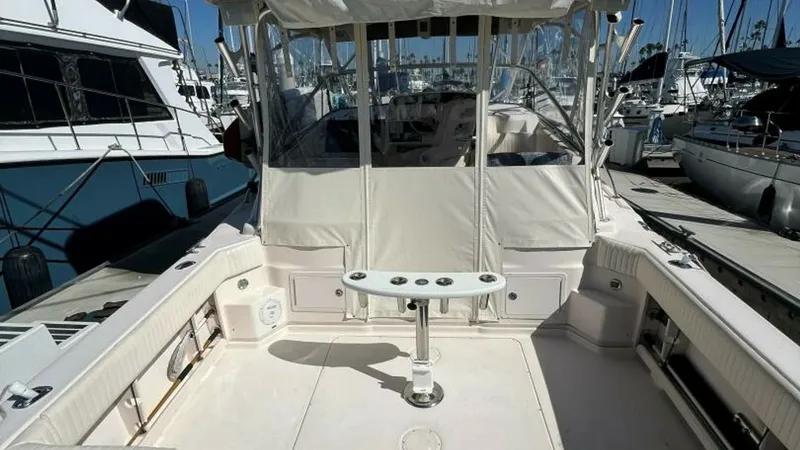 Slide: The Image of 2006 Grady-White 330 Express - "POLE POSITION": Spacious Aft Deck with Rod Holders The aft deck of the 2006 Grady-White 330 Express offers ample space for fishing and relaxation, featuring a central table with integrated rod holders. The area is well-protected with a sturdy hardtop and clear enclosure, providing shelter while maintainin - 6572967