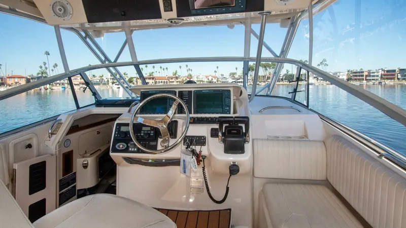 Slide: The Image of 2006 Grady-White 330 Express - "POLE POSITION": Helm Station with Seating The helm station of the 2006 Grady-White 330 Express offers a commanding view with its wrap-around windshield and state-of-the-art navigation systems. The area is equipped with a comfortable captain's chair and additional seating, perfect for companionabl - 6572952