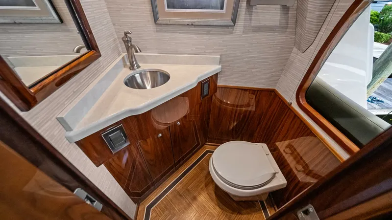 Slide: The Image of Luxurious Guest Head This guest head features elegant wood paneling and a sleek, modern sink with polished fixtures. The space is well-lit, highlighting its sophisticated design and practical layout. The high-quality woodwork and contemporary finishes provide a touch of luxur - 7377891