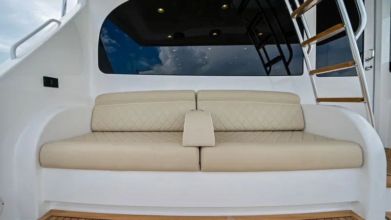 Slide: The Image of Aft Deck with Lounge Seating This inviting aft deck features a luxurious, cushioned lounge seating area with elegant diamond stitching, perfect for relaxation and enjoying the views. The teak flooring enhances the space with its classic, nautical charm. A ladder provides easy access - 7377935