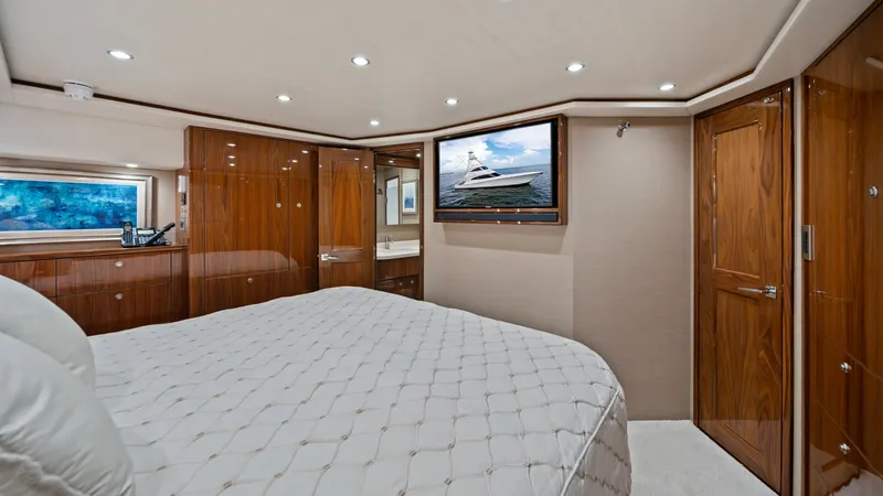 Slide: The Image of Luxurious Master Stateroom with TV This elegant master stateroom on the 2021 Viking 72 Enclosed Bridge features a plush, king-sized bed with premium quilted bedding, creating a serene retreat. The beautifully finished wood cabinetry offers ample storage, while the large window invites natu - 7377906