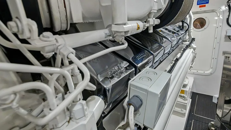 Slide: The Image of Engine Room with Advanced Machinery The engine room of the 2021 Viking 72 Enclosed Bridge showcases meticulously arranged machinery, emphasizing the vessel's engineering excellence. Sleek metallic finishes and organized cabling highlight the attention to detail and commitment to performance - 7377929
