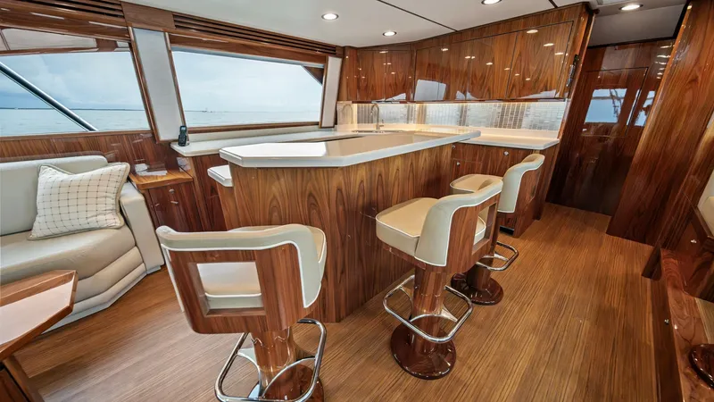 Slide: The Image of Enclosed Bridge Galley and Seating Area This elegant enclosed bridge showcases a beautifully designed galley with a polished wood finish and comfortable bar seating. The sleek countertops and ample natural light create a welcoming atmosphere, while the panoramic windows offer stunning ocean vie - 7377898