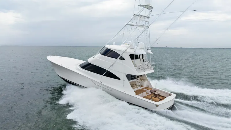 Slide: The Image of Dynamic Aerial View of Viking 72 This aerial shot captures the sleek lines and powerful presence of the 2021 Viking 72 Enclosed Bridge. The vessel is shown cruising effortlessly through the water, highlighting its robust performance and elegant design. The spacious aft deck is visible, p - 7377963