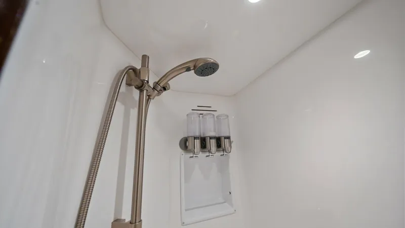 Slide: The Image of Luxurious Enclosed Shower This image showcases the sleek, modern design of the enclosed shower aboard the Viking 72 Enclosed Bridge. Featuring a high-end adjustable showerhead and integrated dispensers, this space combines functionality with elegance. The bright, seamless finish a - 7377909