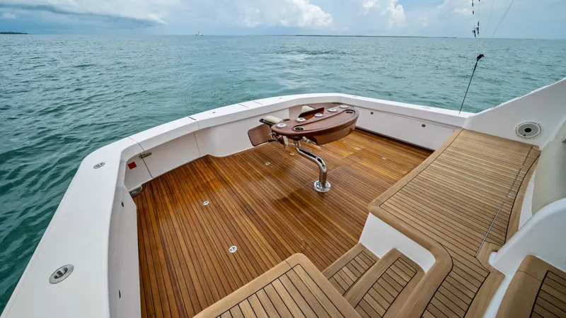 Slide: The Image of Spacious Teak Cockpit Area This image showcases the expansive teak cockpit of the 2021 Viking 72 Enclosed Bridge. The cockpit features a high-quality teak sole, providing both durability and elegance, ideal for fishing or leisure activities. The central fighting chair is a standout - 7377945