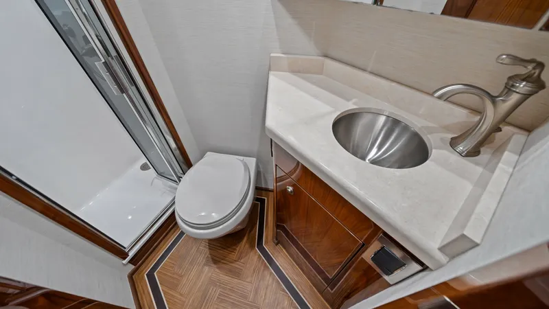 Slide: The Image of Private Ensuite Bathroom This elegantly designed ensuite bathroom features a sleek, modern sink with a polished chrome faucet and a spacious shower area. The high-gloss wood cabinetry and beautiful flooring add a touch of luxury, while the well-placed lighting creates a bright an - 7377915