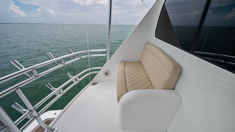 Slide: The Image of Flybridge Seating with Ocean View This image showcases the comfortable seating area on the flybridge of the 2021 Viking 72 Enclosed Bridge. The elegant, cushioned bench offers a relaxing spot to enjoy unobstructed ocean views. The sleek stainless steel railings and expansive windows enhan - 7377880