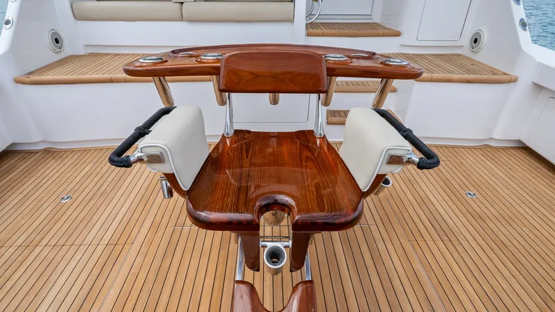 Slide: The Image of Cockpit with Fighting Chair This image showcases the cockpit area featuring a beautifully crafted fighting chair, ideal for sportfishing enthusiasts. The teak decking adds a touch of elegance and durability, while the cushioned aft seating offers comfort for passengers. The layout i - 7377943