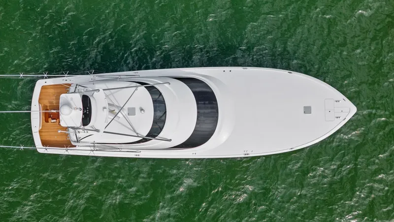 Slide: The Image of Aerial View of Forward Deck This aerial shot of the 2021 Viking 72 Enclosed Bridge showcases the sleek, streamlined design of the forward deck, emphasizing its expansive, unobstructed layout. The elegant curvature and the pristine white finish highlight the vessel's craftsmanship. T - 7377960
