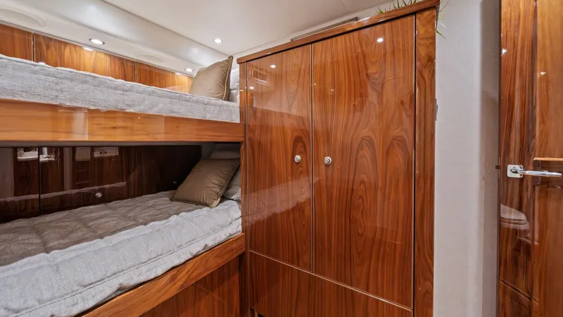 Slide: The Image of Guest Cabin with Bunk Beds This cozy guest cabin features beautifully crafted wooden cabinetry and comfortable bunk beds, perfect for accommodating additional guests. The rich wood finish adds warmth and elegance, complemented by subtle recessed lighting. Soft bedding and plush pil - 7377925