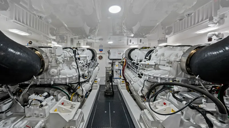 Slide: The Image of Engine Room with Twin Engines The engine room of the 2021 Viking 72 Enclosed Bridge showcases its powerful twin engines, meticulously designed for optimal performance. The pristine white finish and organized layout ensure easy access and maintenance. Advanced engineering and high-qual - 7377923