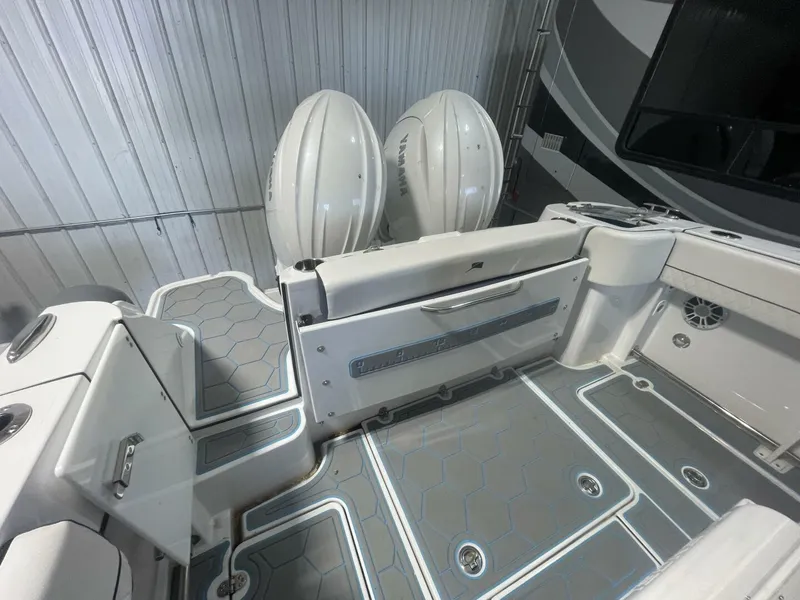 Slide: The Image of Aft Seating and Transom Storage – Stingray Center Console Interior stern view featuring fold-down aft seating, fish ruler, non-skid decking, and access to Yamaha outboards—great for detailing onboard amenities. - 5799740