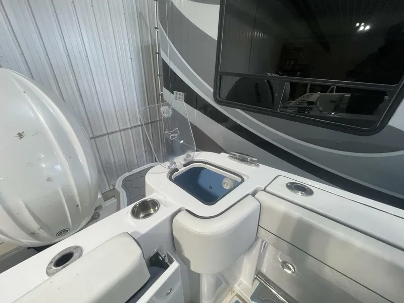 Slide: The Image of Aft Livewell and Bait Prep Station on Center Console Fishing Boat High-capacity blue livewell with clear lid, sink, and cup holders on the aft deck of a center console fishing boat. Ideal for offshore anglers looking for integrated bait prep features. - 5799738