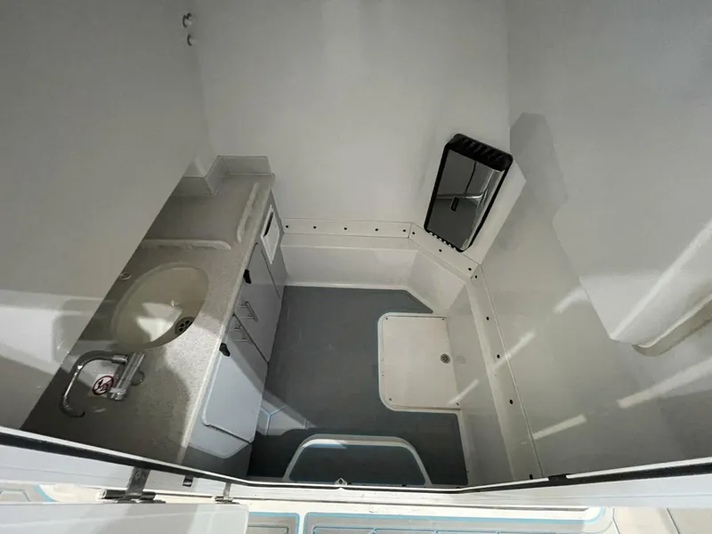 Slide: The Image of Center Console Boat Head Compartment with Sink and Storage Interior head compartment featuring sink, countertop, and ample floor space. Practical and clean design for family comfort during full-day boating. - 5799731