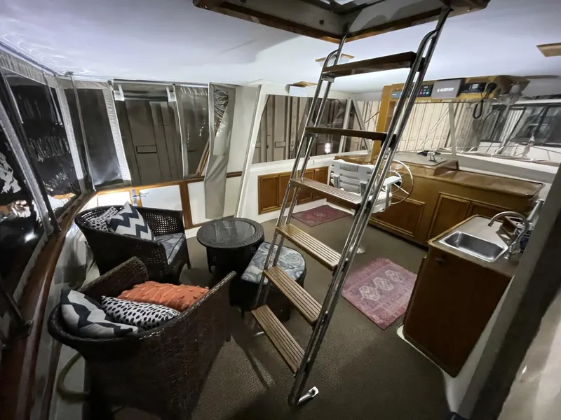 Slide: The Image of Enclosed Aft Deck Lounge with Helm Access – 1986 Egg Harbor 40 Spacious enclosed aft deck featuring wicker seating, updated cushions, and direct access to the upper helm—clean, comfortable, and ideal for entertaining. - 5808864