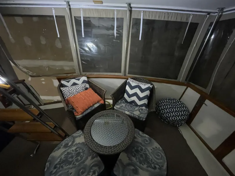 Slide: The Image of Aft Deck Seating Area with Wicker Chairs – Egg Harbor 40 Motor Yacht Cozy aft deck conversation area with dual wicker chairs, patterned cushions, and ottoman—well-kept and perfect for relaxing onboard. - 5808863