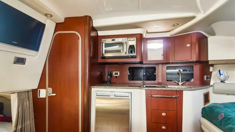 Slide: The Image of Galley with Modern Appliances This well-appointed galley on the Boston Whaler 34 Outrage features rich wooden cabinetry and sleek countertops. Equipped with a built-in microwave and ample storage, it provides all the conveniences needed for a comfortable journey. The stainless steel a - 7672499