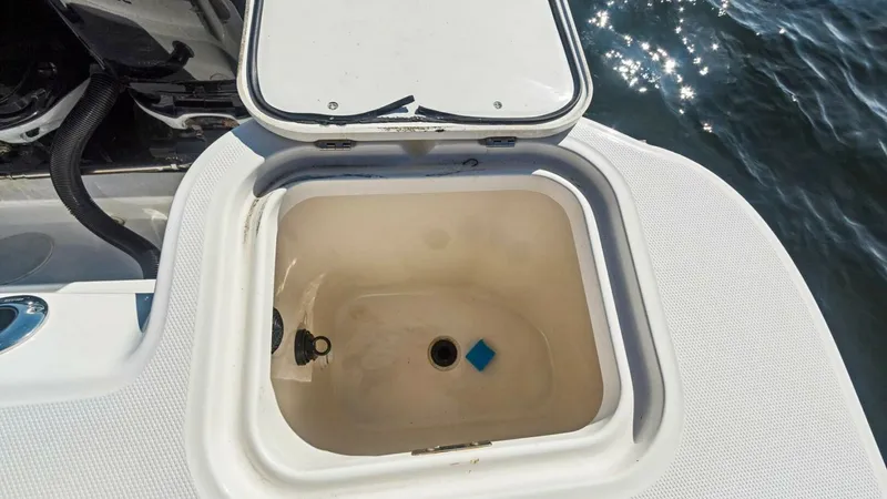 Slide: The Image of Aft Deck Livewell Compartment This image showcases the aft deck livewell of the 2008 Boston Whaler 34 Outrage. The spacious compartment is designed for keeping bait fresh, with a secure lid to prevent spills in rough waters. Its strategic placement near the transom ensures easy access - 7672509