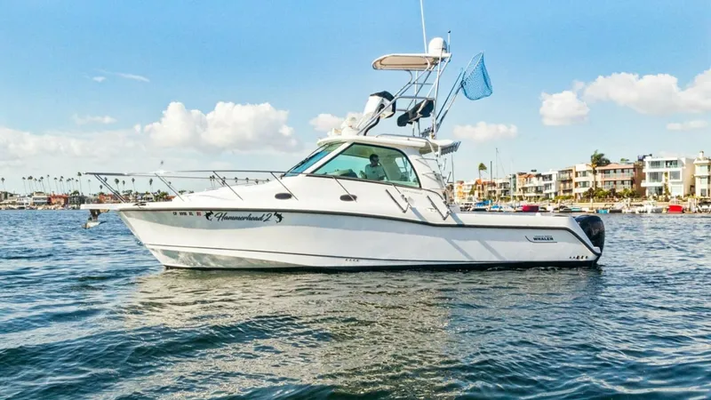Slide: The Image of Side Profile of Boston Whaler 34 Outrage The 2008 Boston Whaler 34 Outrage, named HAMMERHEAD II, showcases its sleek side profile against a serene coastal backdrop. This vessel is equipped with a robust center console and a well-designed hardtop, ideal for both fishing and leisure. The clean lin - 7672514