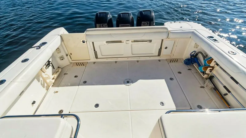 Slide: The Image of Spacious Aft Deck with Triple Engines This image showcases the expansive aft deck of the 2008 Boston Whaler 34 Outrage, featuring ample space for fishing and leisure activities. The deck is equipped with sturdy rod holders and clean, non-slip surfaces, ensuring a safe and functional environme - 7672508