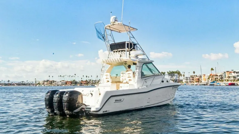 Slide: The Image of Aft View with Triple Outboards This image showcases the powerful aft section of the 2008 Boston Whaler 34 Outrage, featuring three robust outboard engines for exceptional performance. The spacious deck is designed for both leisure and fishing, equipped with ample seating and storage op - 7672515