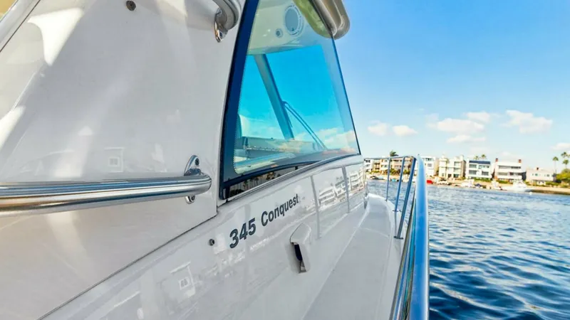 Slide: The Image of Starboard Exterior with Railings This image showcases the sleek starboard exterior of the Boston Whaler 34 Outrage. The polished stainless steel railings provide both safety and style, complementing the vessel's clean lines. Large windows offer ample natural light and stunning views, enh - 7672512