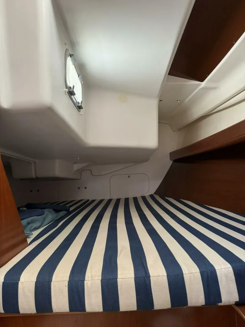Slide: The Image of Port Aft Berth Oversized queen double berth, hanging locker, shelves alongside the hull and stowage space under berth. - 5822380