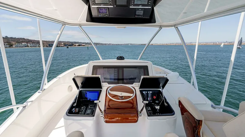Slide: The Image of Skybridge Helm Station View The helm station on the 2019 Viking 80 Skybridge offers a commanding view with state-of-the-art navigation systems and dual control panels. The sleek, polished wood accents enhance the luxurious feel, while the comfortable seating ensures a pleasant exper - 6478747