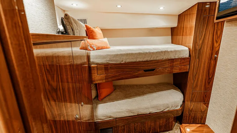 Slide: The Image of Guest Stateroom with Bunk Beds This cozy guest stateroom features elegant bunk beds with plush bedding, providing a comfortable retreat for guests. The high-gloss wood finish adds a touch of luxury, complemented by subtle recessed lighting that enhances the warmth of the space. Thought - 6478726