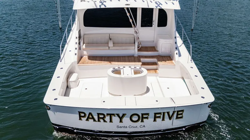 Slide: The Image of Spacious Aft Deck with Seating The aft deck of the 2019 Viking 80 Skybridge, 'PARTY OF FIVE,' showcases a generous seating area perfect for relaxation and entertaining. The deck features elegant teak flooring and a central baitwell, ideal for fishing enthusiasts. The open design offers - 6478766
