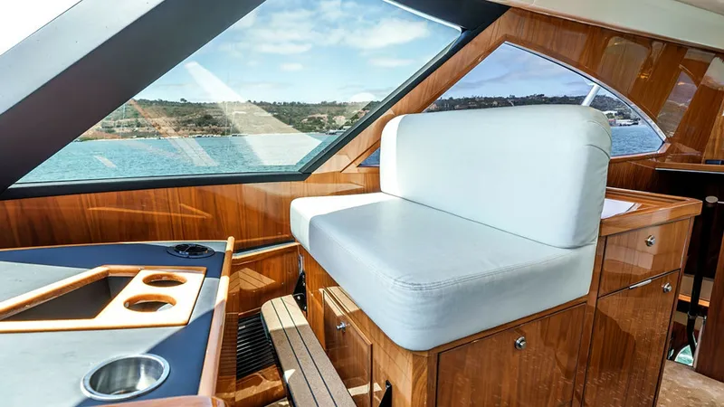 Slide: The Image of Skybridge Helm Seating Area The skybridge of the Viking 80 features a luxurious helm seating area with panoramic views. Elegant wood finishes complement the plush, cushioned seating, providing comfort and style. The ample natural light enhances the sophisticated design, making it an - 6478744
