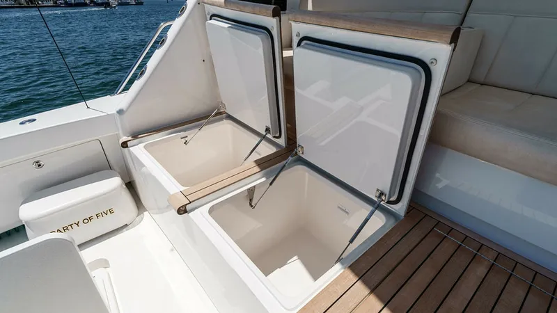 Slide: The Image of Aft Deck Storage and Seating Area This aft deck of the 2019 Viking 80 Skybridge features spacious storage compartments, perfect for keeping essentials secure and organized. The teak decking adds a touch of elegance, while the adjacent cushioned seating offers comfort for guests. The open - 6478758