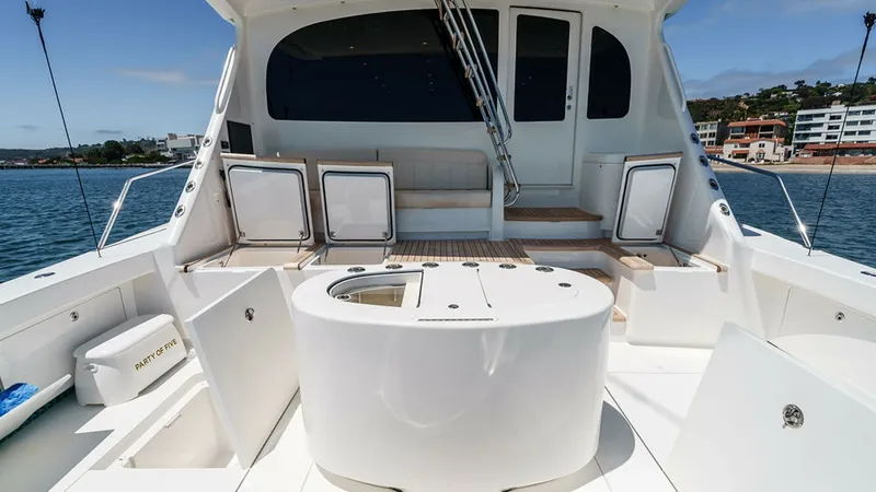 Slide: The Image of Spacious Cockpit with Seating Area The cockpit of the 2019 Viking 80 Skybridge, PARTY OF FIVE, offers a well-appointed space designed for relaxation and entertainment. It features a comfortable seating area with neatly integrated storage options and a central prep station, ideal for fishin - 6478759
