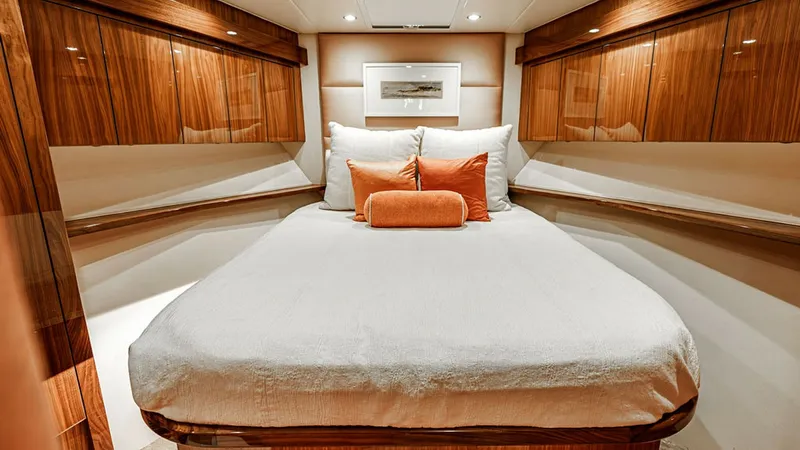 Slide: The Image of Luxurious Forward Stateroom This elegant forward stateroom on the 2019 Viking 80 Skybridge features a spacious double bed with plush linens and accent pillows for added comfort. The rich wood finishes and ambient recessed lighting create a warm and inviting atmosphere. Ample storage - 6478732