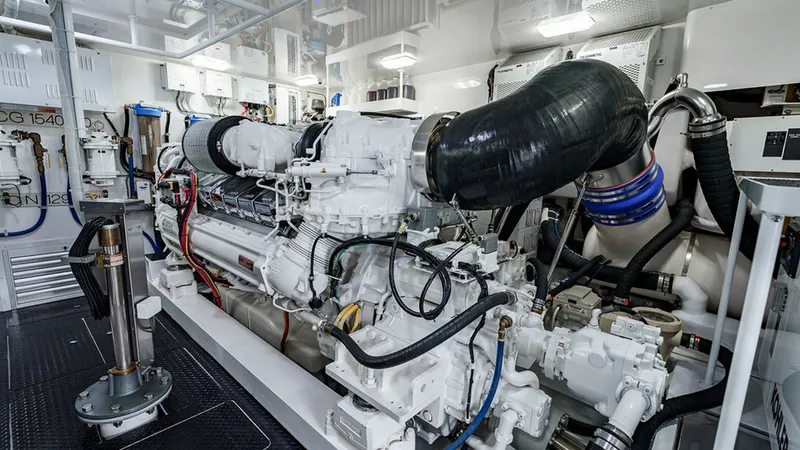 Slide: The Image of Engine Room with Twin Engines This image showcases the meticulously organized engine room of the 2019 Viking 80 Skybridge. Featuring powerful twin engines, the space is designed for optimal performance and ease of maintenance. The clean, white finishes and strategic layout emphasize b - 6478754