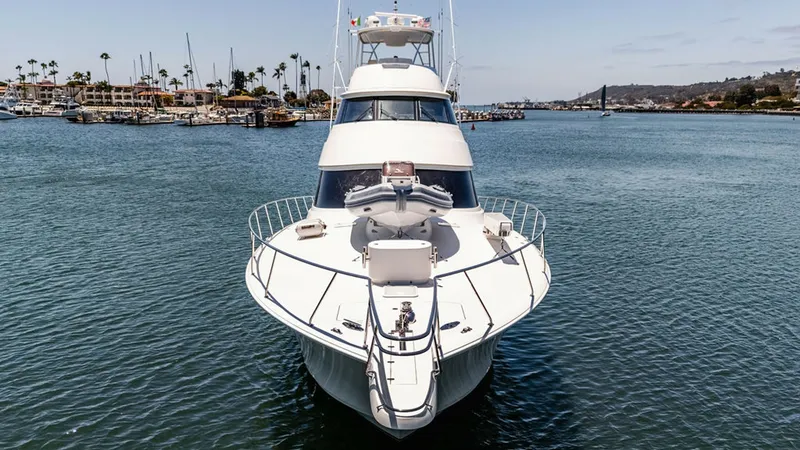 Slide: The Image of Bow View of Viking 80 Skybridge This image showcases the impressive bow of the 2019 Viking 80 Skybridge, 'PARTY OF FIVE.' The sleek, aerodynamic design is complemented by sturdy railings and a spacious foredeck, ideal for sunbathing or enjoying panoramic views. The vessel's elegant line - 6478774